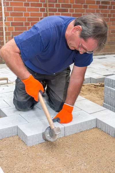 Constructor instalando nuevas piedras de pavimentación Imagen De Stock