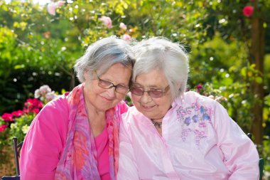 İki üst düzey Arkadaşlar Bahçe içinde gülümseyen açık portresi