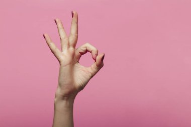 2020 yılının bir parçası olarak sıfır numarayı gösteren kadın elleri, pembe arka planda işaret dili, tamam mı?