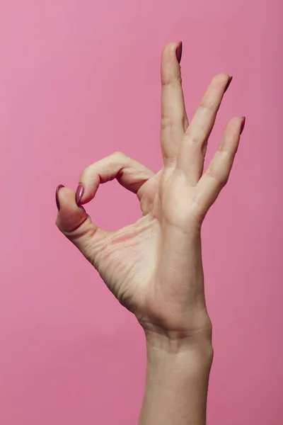 Manos femeninas que muestran el número cero como parte de la fecha del nuevo año 2020, lenguaje de signos sobre un fondo rosa de color, gesto ok — Foto de Stock