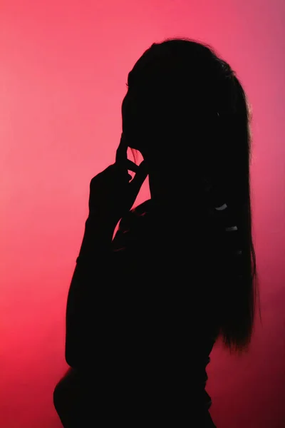 Silhouette Ragazza Premurosa Sfondo Rosso Alleggerito Profilo Donna Irriconoscibile Con — Foto Stock