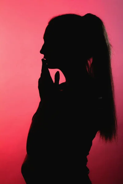 Silhouette Ragazza Premurosa Sfondo Rosso Alleggerito Profilo Viso Donna Irriconoscibile — Foto Stock