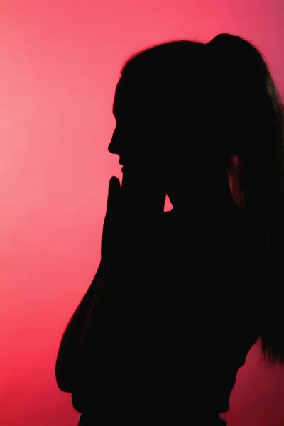 Silhouette Ragazza Spaventata Sfondo Rosso Alleggerito Profilo Viso Donna Irriconoscibile — Foto Stock