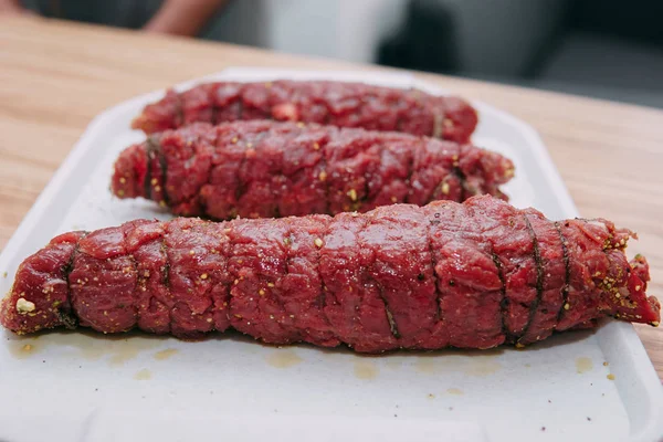 Cooking meat rolls in a cooking class. Beef roll with spices. Raw meat, close-up.