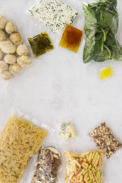 Set of products for Italian dinner: pasta, spinach, mushrooms, apples, nuts, olive oil, sauces and spices. A set for delivering food for dinner. Cooking at home, home cooking. Flat lay. Products in vacuum packaging.