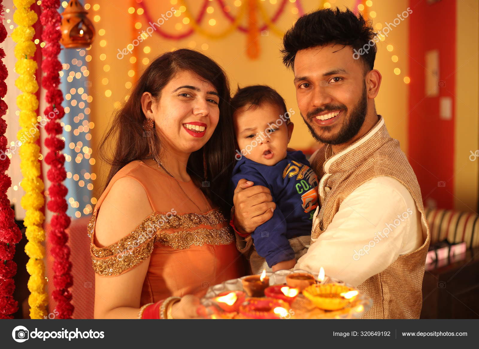 Indian Attractive Couple In Traditional Wear Celebrating Diwali Festival,  Birthday Or Anniversary With Surprise Gifts And Sweet Laddoo Against  Decorated Background With Marigold Flowers Stock Photo, Picture and Royalty  Free Image. Image