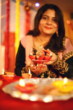 Diwali Stüdyo portresi vesilesiyle dekoratif arkaplanlı geleneksel diwali festivalini kutlayan Hintli genç güzel bir kadının portresi..