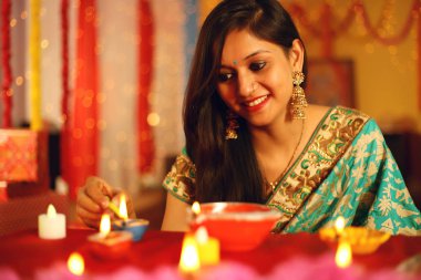 Diwali Stüdyo portresi vesilesiyle dekoratif arkaplanlı geleneksel diwali festivalini kutlayan Hintli genç güzel bir kadının portresi..