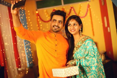 Hintli çift Diwali 'yi kutluyor. Dekoratif arkaplanda izole.