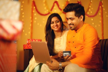  Hintli çift Diwali 'yi kutluyor. Dekoratif bir arka planda izole edilmiş.