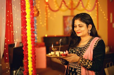 Diwali festivalini kutlayan geleneksel sari elbiseli güzel bir Hintli kadının portresi. Dekoratif arka planda Diwali, Stüdyo portresi vesilesiyle..
