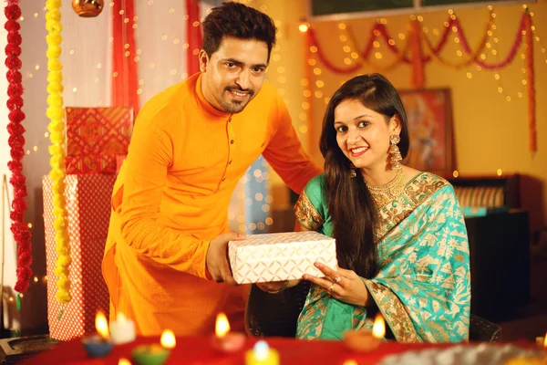 Hintli çift Diwali 'yi kutluyor. Dekoratif arkaplanda izole.