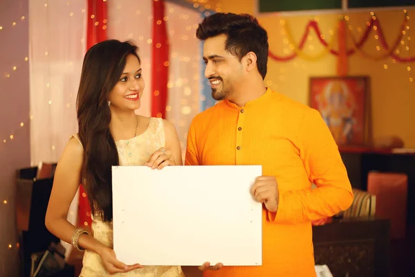 Hintli çift Diwali 'yi kutluyor. Dekoratif arkaplanda izole.