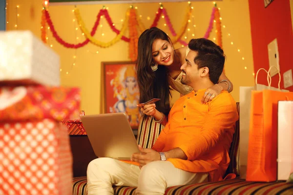 Hintli çift Diwali 'yi kutluyor. Dekoratif bir arka planda izole edilmiş.