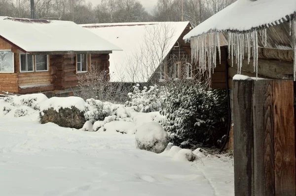 屋根からつららが吊るされ雪に覆われた冬の観光用の家 — ストック写真