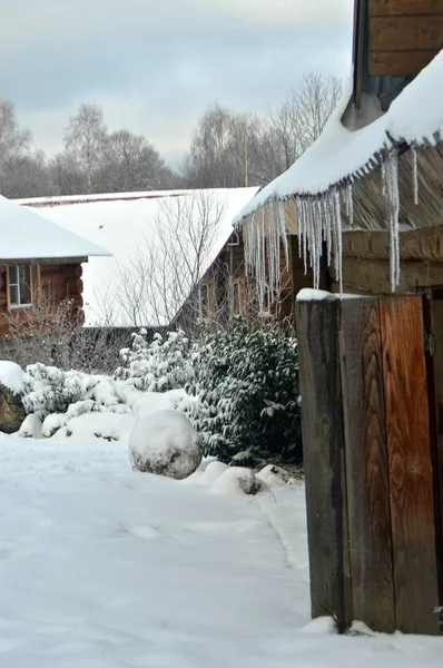 屋根からつららが吊るされ雪に覆われた冬の観光用の家 — ストック写真