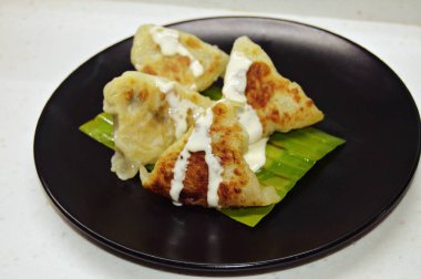 Hamur üçgeni şeklinde bir yemek, içinde sebze dolgusu olan yemek, sos ile doldurulur.