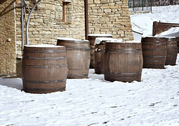 wooden wine barrels stand outside in winter