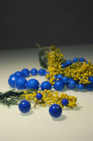 blue beads and earrings with mimosa, bright blue necklace of round beads and round earrings with a delicate yellow bouquet of mimosa