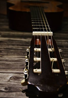 Akustik klasik gitar, yazı için alanı olan ahşap bir arka planda yatar.