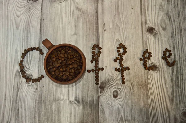 coffee inscription made of coffee beans, the letter O is replaced by a brown round mug with coffee beans inside