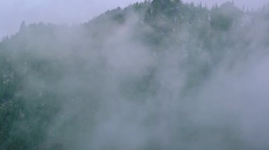 Sis ve bulut içinde yüksek dağ sıraları