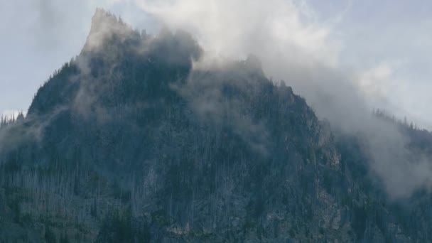 Overcast alpine view with mountain silhoette fragments through fog and clouds. — Stock Video