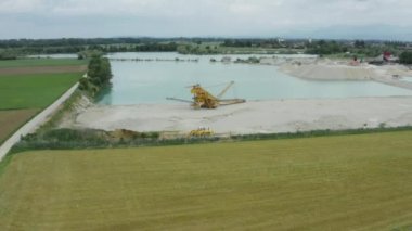 Durmuş bir Bucket Wheel Excavator kumlu kazı sahasında oturuyor.