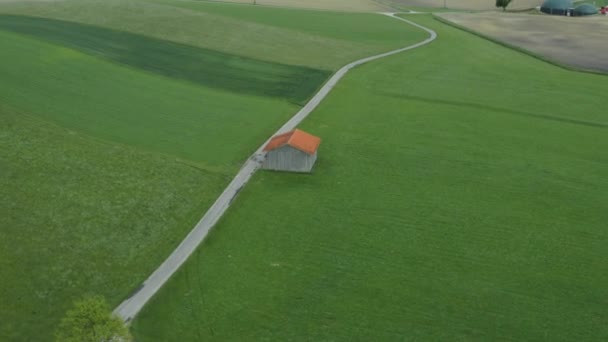 Uma estrada que atravessa as belas terras verdes — Vídeo de Stock