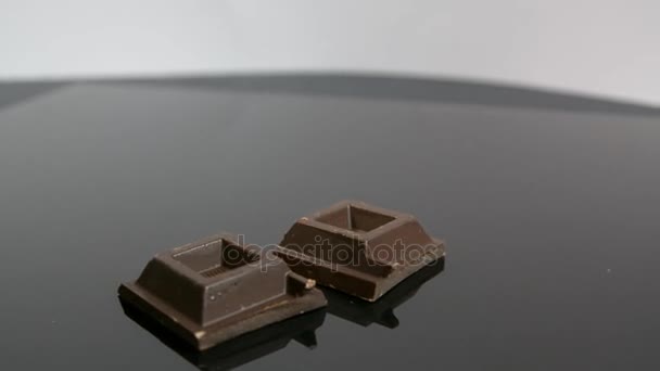 Pieces of chocolate bar falling on neutral background — Stock Video