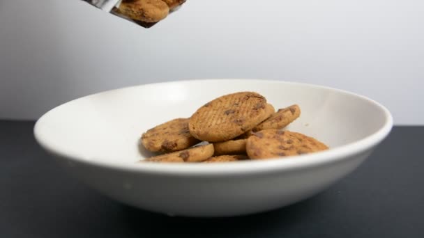 Cookies falling into white bowl — Stock Video