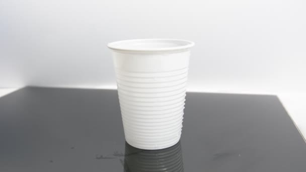 Вода льется в пластиковую чашку — стоковое видео