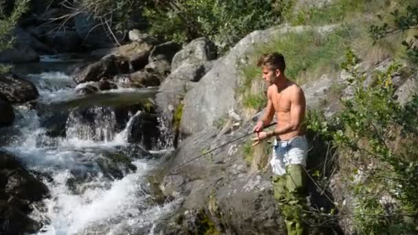 Человек рыбалка с удочкой на реке — стоковое видео