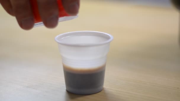 Hand gieten van suiker in een kop koffie — Stockvideo