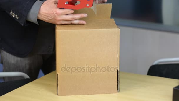 Male hands packing box with self-adhesive duct tape — Stock Video