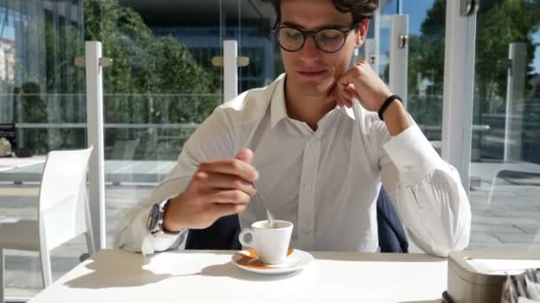 Елегантний молодий чоловік п'є каву надворі — стокове відео