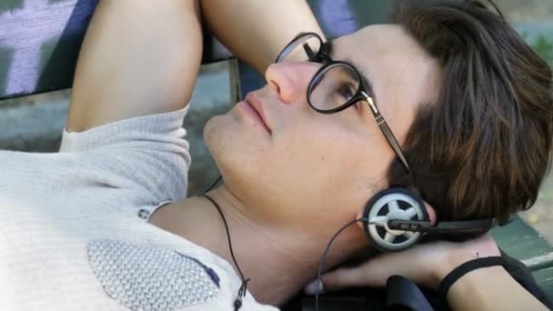 Νεαρός άνδρας, ακούγοντας μουσική στο πάρκο — Αρχείο Βίντεο