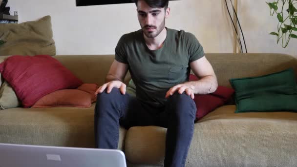 Νεαρός άνδρας κάνει videochat στο σπίτι σε φορητό υπολογιστή — Αρχείο Βίντεο