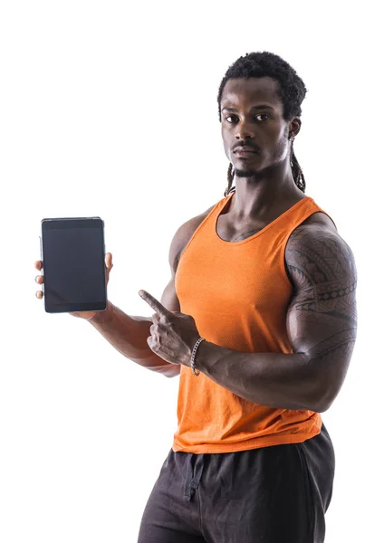 Чернокожий молодой человек держит и показывает планшетный компьютер — стоковое фото