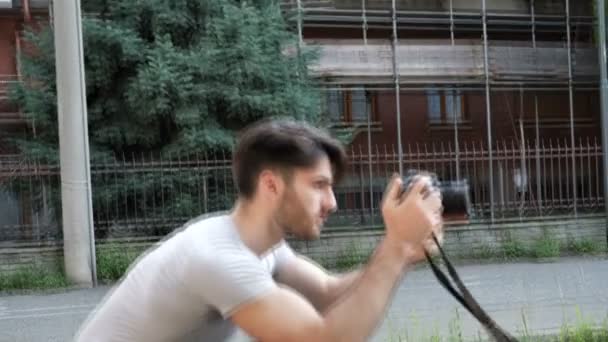 Красивий молодий чоловічий фотограф фотографує — стокове відео