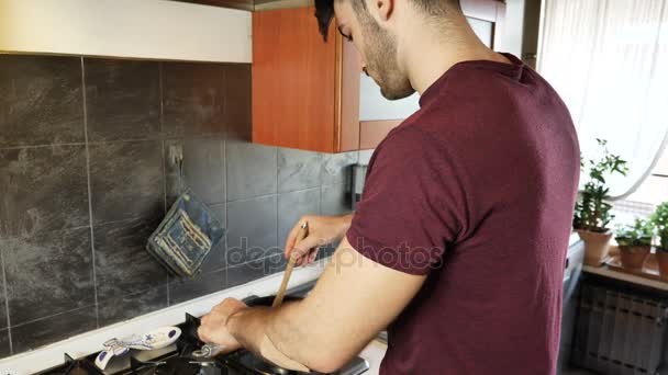 Hombre quemándose el dedo mientras cocina — Vídeos de Stock