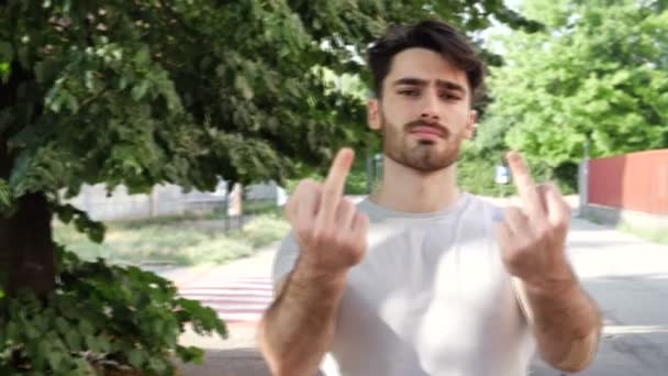 Молодой человек показывает средний палец жестикулируя к черту вас — стоковое видео