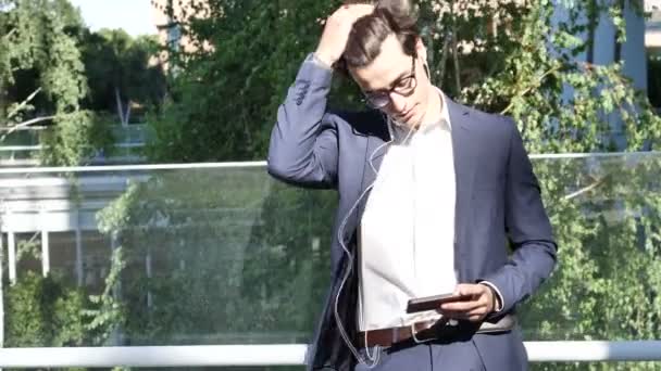 Stilvoller junger Geschäftsmann mit Kopfhörern — Stockvideo