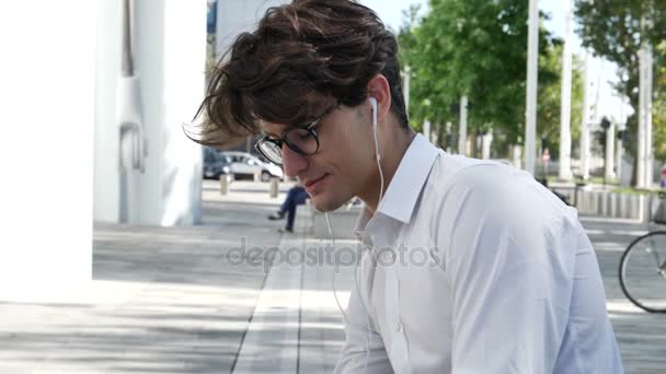 Homem de negócios jovem elegante com fones de ouvido — Vídeo de Stock