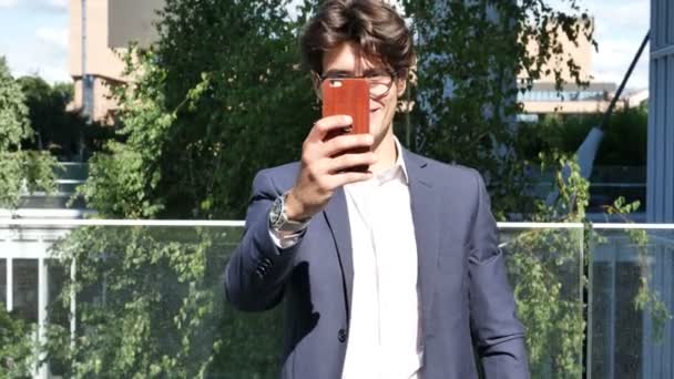 Joven en la ciudad tomando fotos con teléfono celular — Vídeos de Stock