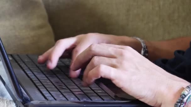 若い男がソファの上のラップトップ上の宿題 — ストック動画