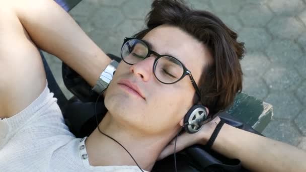 Joven escuchando música en el parque — Vídeos de Stock