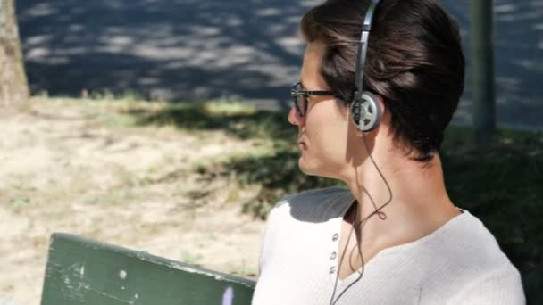 Jeune homme écoutant de la musique dans le parc — Video