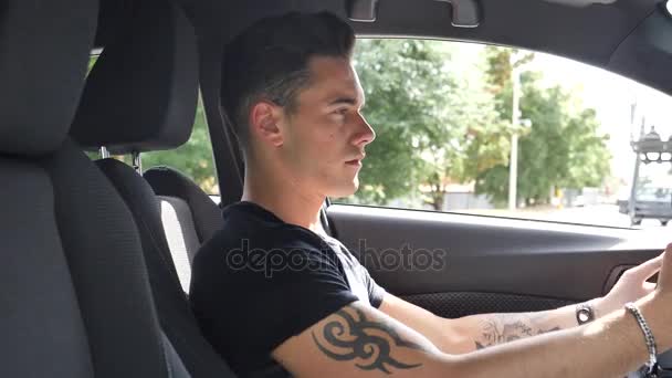 Młody człowiek za pomocą jego telefon komórkowy jazdy samochodu — Wideo stockowe