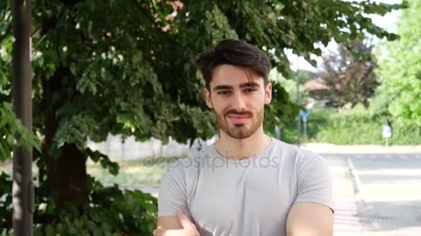 Guapo joven sonriendo al aire libre — Vídeo de stock